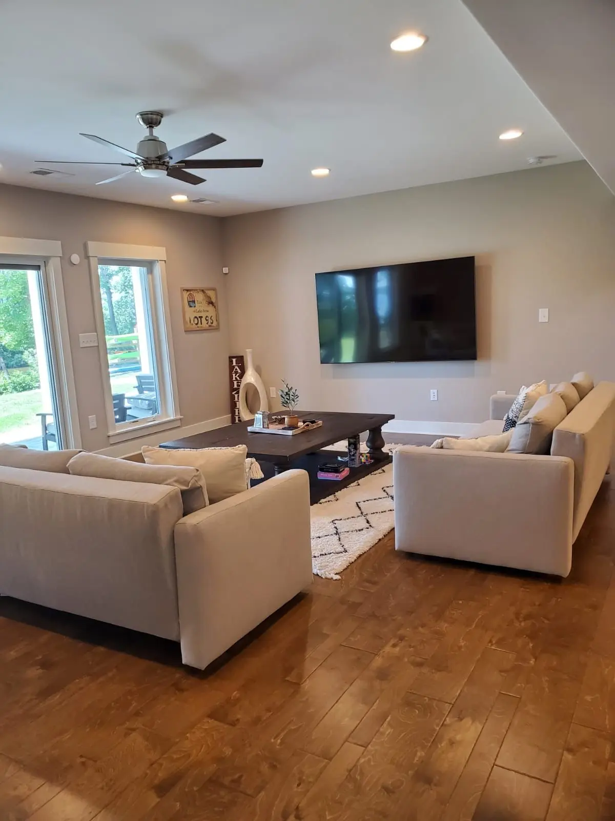 A pristine living room with light-colored sofas and hardwood floors, reflecting the meticulous living room cleaning service provided by Brighthouse Cleaners.