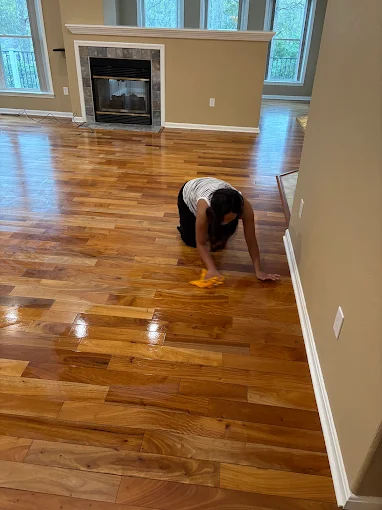 A Brighthouse Cleaners professional providing a detailed one-time cleaning service by hand-polishing a shiny hardwood floor.