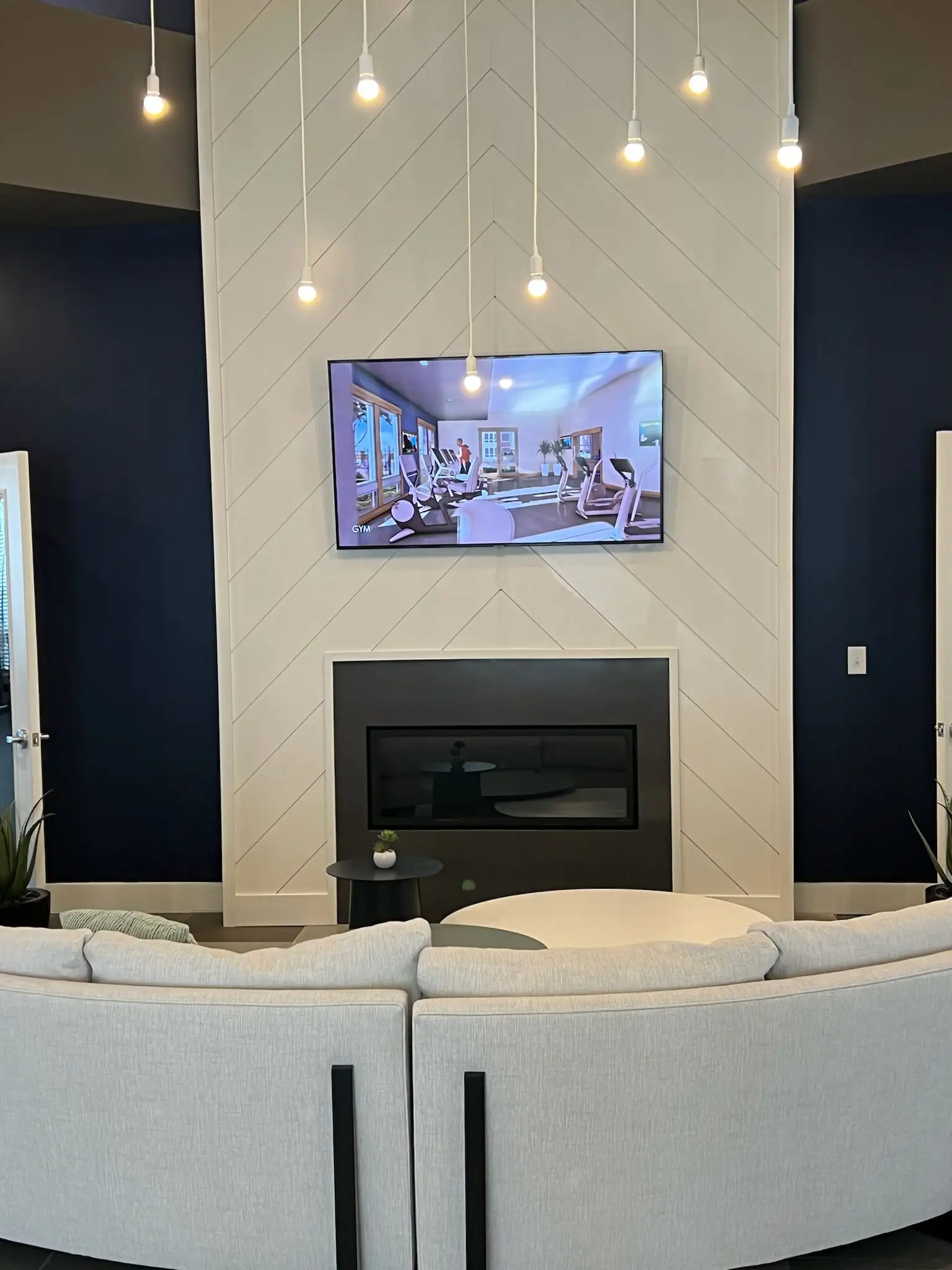 A modern and impeccably clean apartment lounge area, maintained with professional apartment cleaning service by Brighthouse Cleaners, featuring stylish decor and a mounted TV.