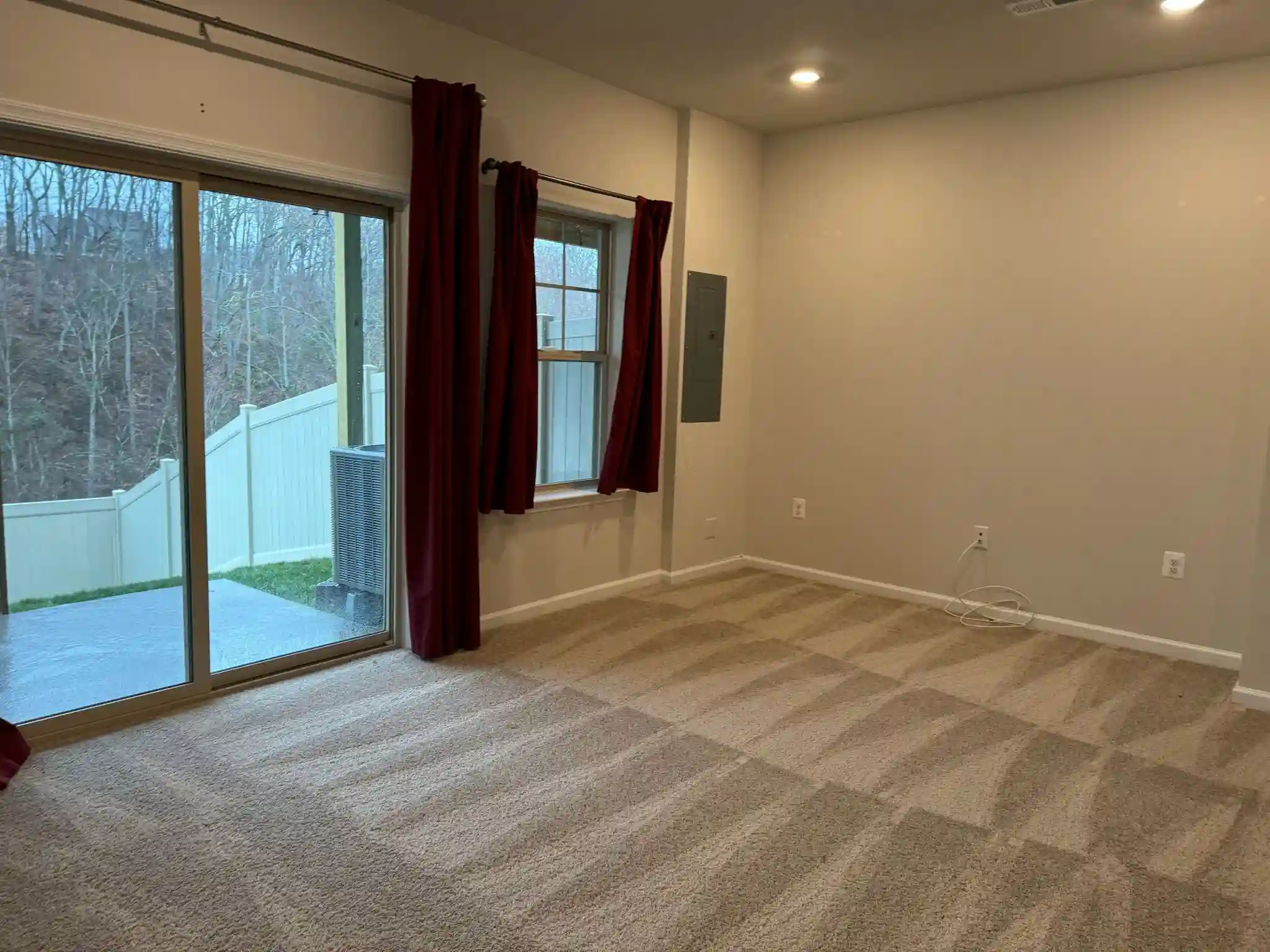 An empty room with freshly vacuumed carpets, expertly prepared by Brighthouse Cleaners' professional post-construction cleaning service.